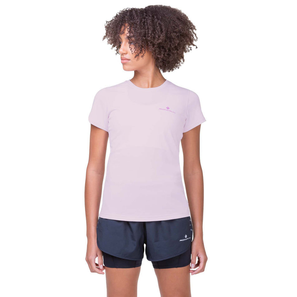 Front view of a model wearing a Ronhill Women's Core S/S Tee in the Ballet/Fuchsia colourway. Model is also wearing Ronhill shorts.  (8160858243234)