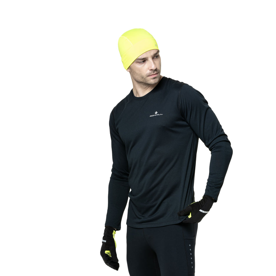 Front view of a model wearing the Ronhill Men's Core L/S Tee in the Black/Bright White colourway. (8748682608802)