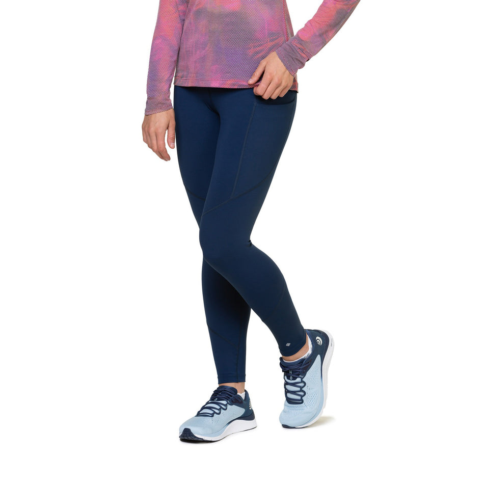 Front view of a model wearing the Ronhill Women's Tech Tight in the Dark Navy colourway. Model is also wearing socks, shoes and a top. (8469366079650)
