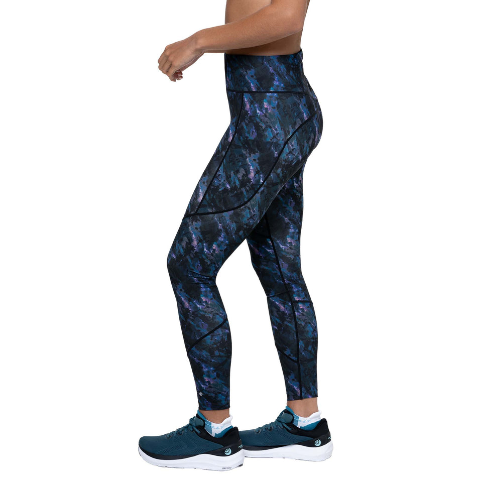 Side view of a model wearing the Ronhill Women's Tech Tight in the Cosmic colourway. (8747579211938)