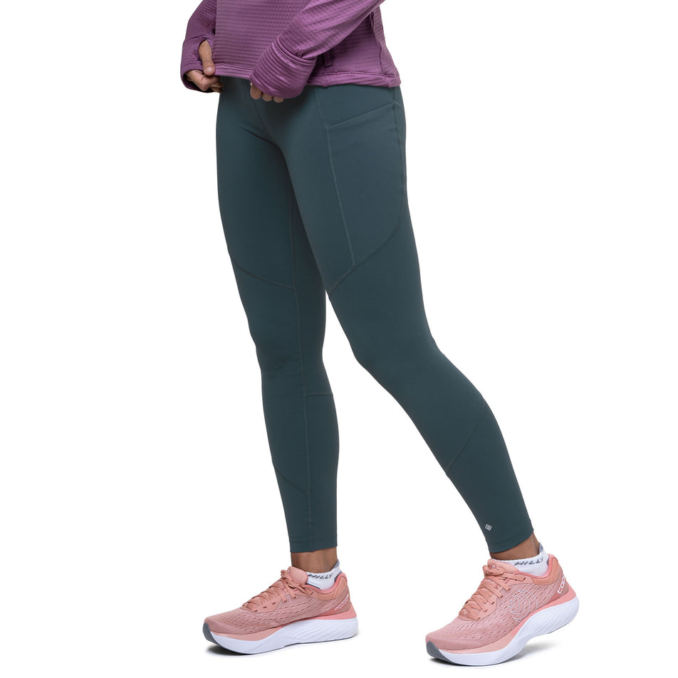 Angled view of a model wearing the Ronhill Women's Tech Tight in the Evening Haze colourway. (8742711853218)