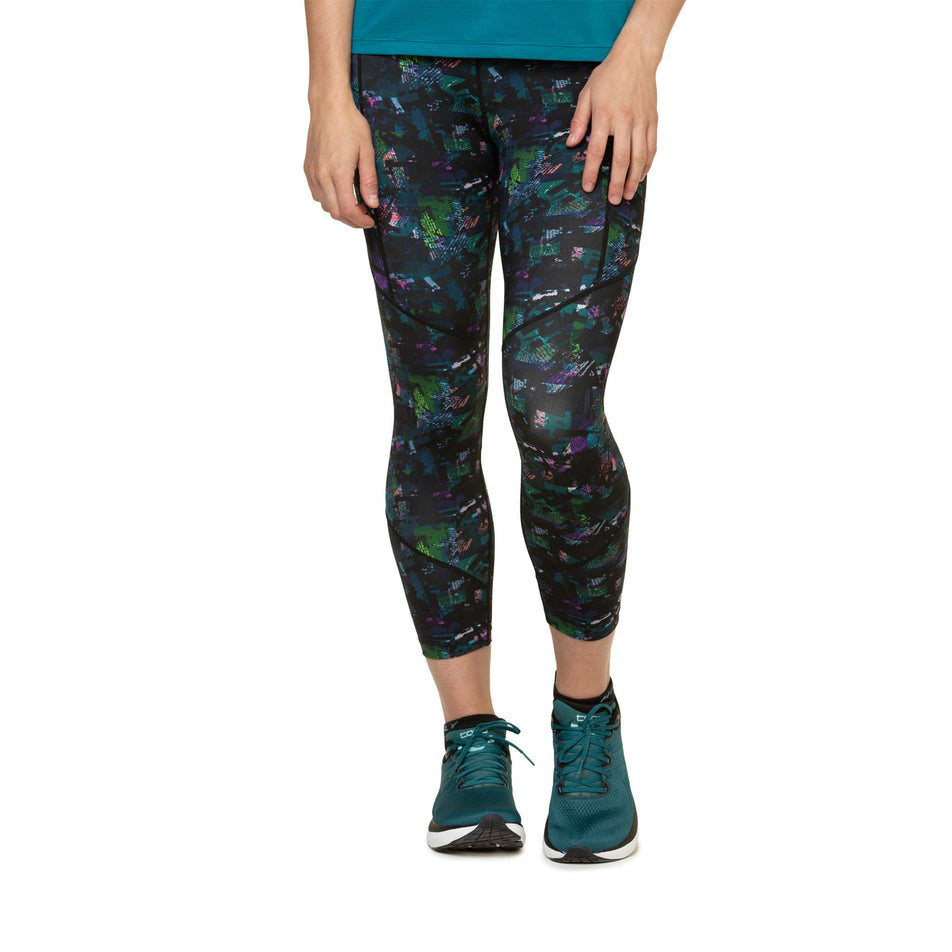 Front view of a model wearing the Ronhill Women's Tech Crop Tight in the Digital Jungle colourway. Model is also wearing shoes and a top. (8490037543074)