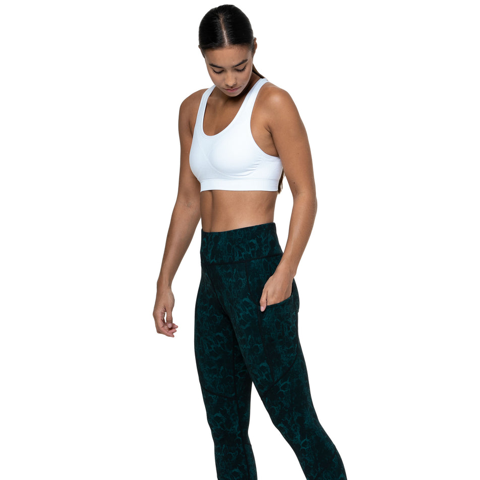 Angled view of a model wearing the Ronhill Women's Tech Crop Tight in the Seaweed Medusa colourway. (8747588911266)