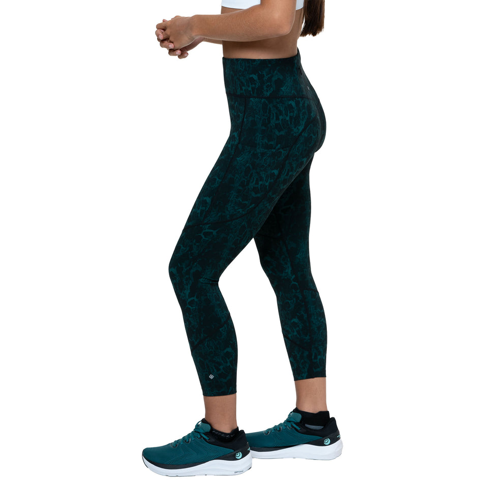 Side view of a model wearing the Ronhill Women's Tech Crop Tight in the Seaweed Medusa colourway. (8747588911266)