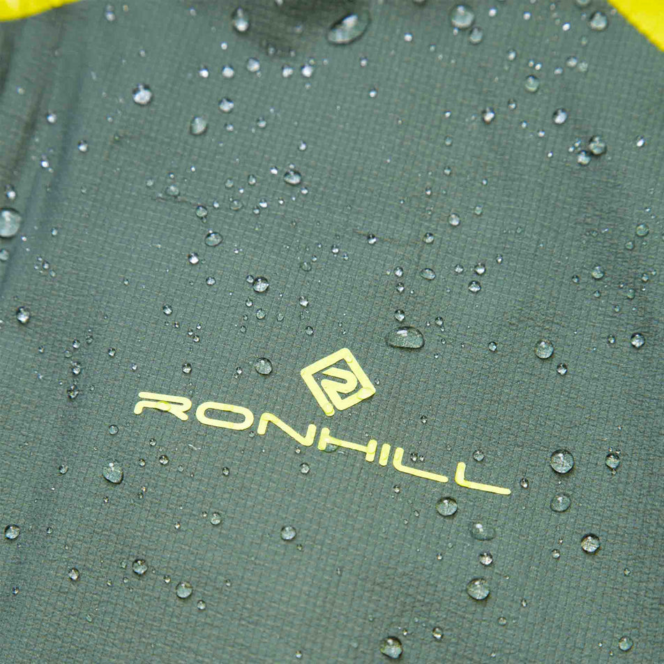 Close-up of the Ronhill logo on a Ronhill Men's Tech Fortify Jacket. There are beads of water on the fabric. (8470624895138)