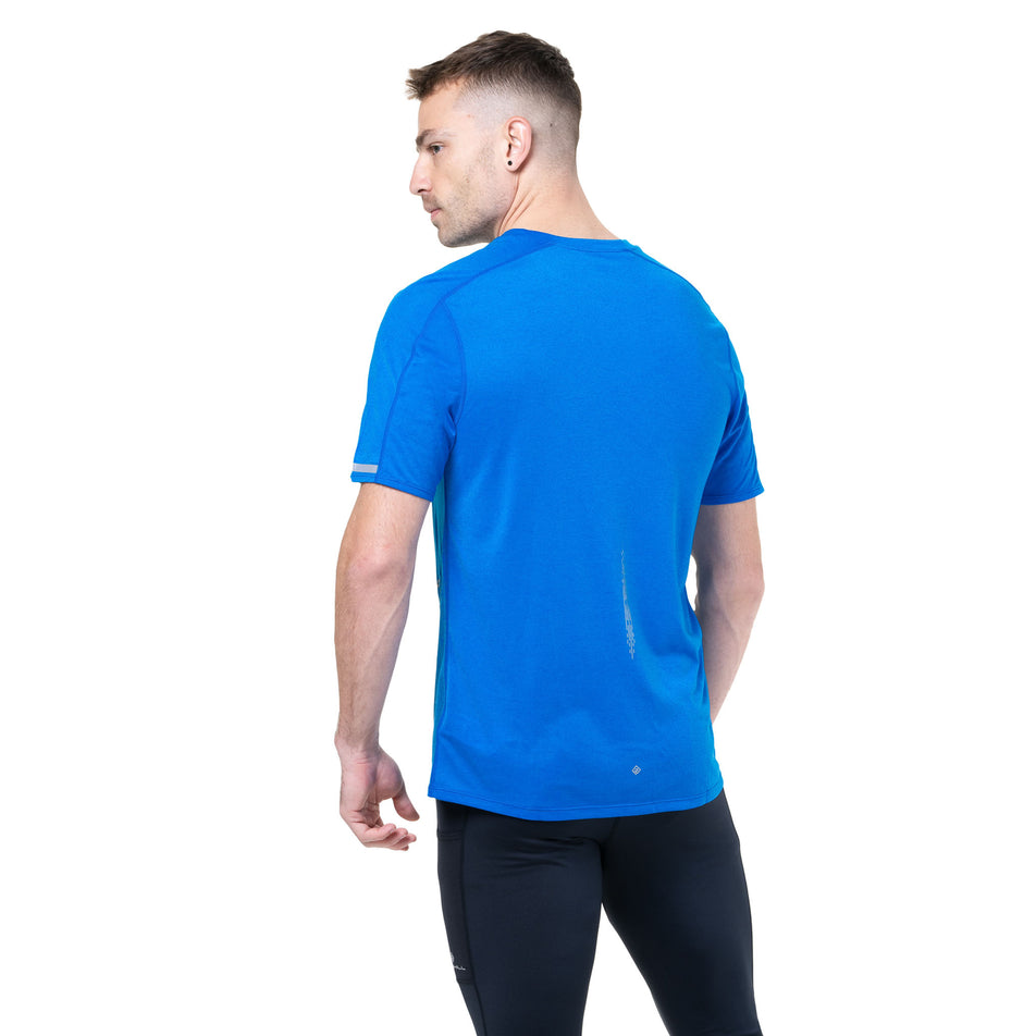 Back view of a model wearing the Ronhill Men's Tech Reflect S/S Tee in the ElecBlueMarl/Reflect colourway.(8747641831586)