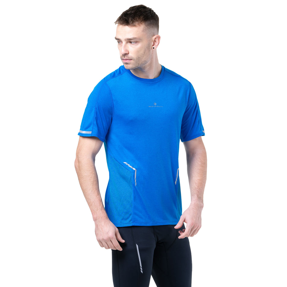 Front view of a model wearing the Ronhill Men's Tech Reflect S/S Tee in the ElecBlueMarl/Reflect colourway.(8747641831586)