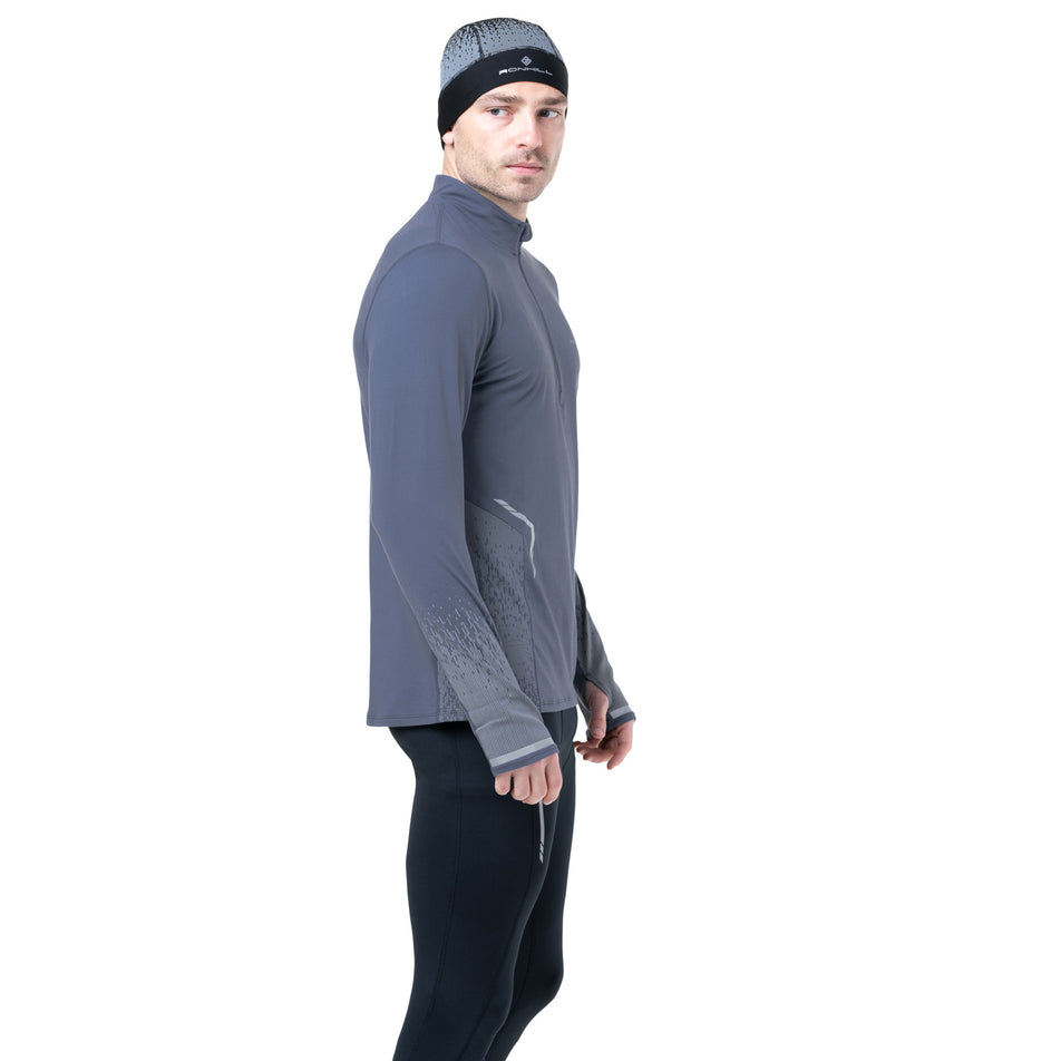 Side view of a model wearing the Ronhill Men's Tech Reflect 1/2 Zip in the Anchor/Reflect colourway. (8747638522018)