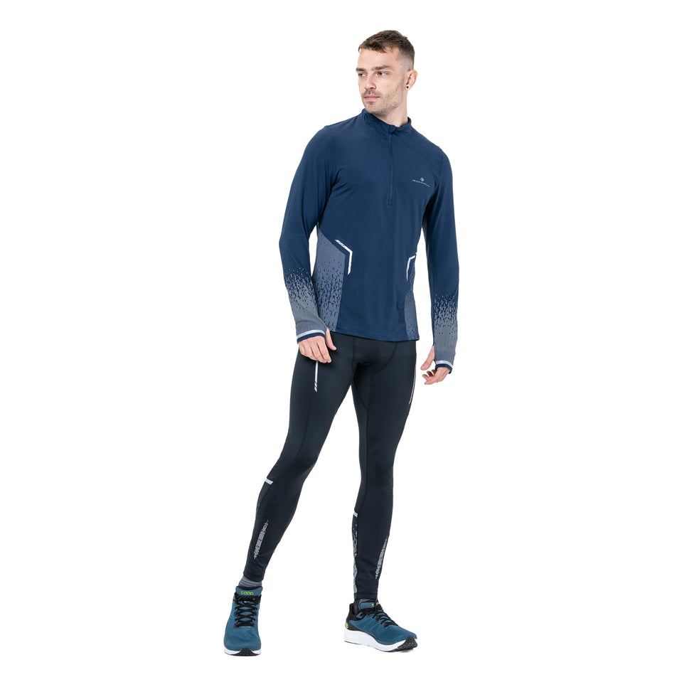 Front view of a model wearing the Ronhill Men's Tech Reflect 1/2 Zip in the Dark Navy/Reflect colourway. (8742775455906)