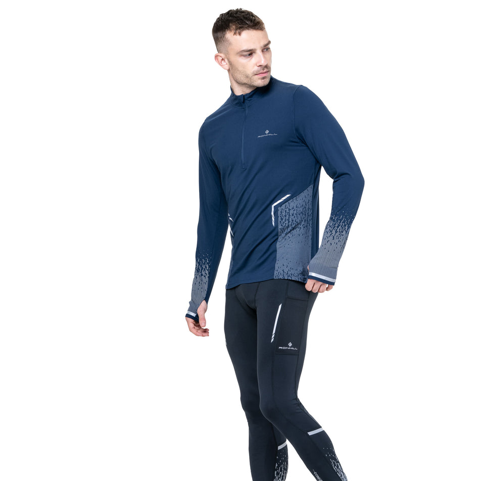 Front view of a model wearing the Ronhill Men's Tech Reflect 1/2 Zip in the Dark Navy/Reflect colourway. (8742775455906)