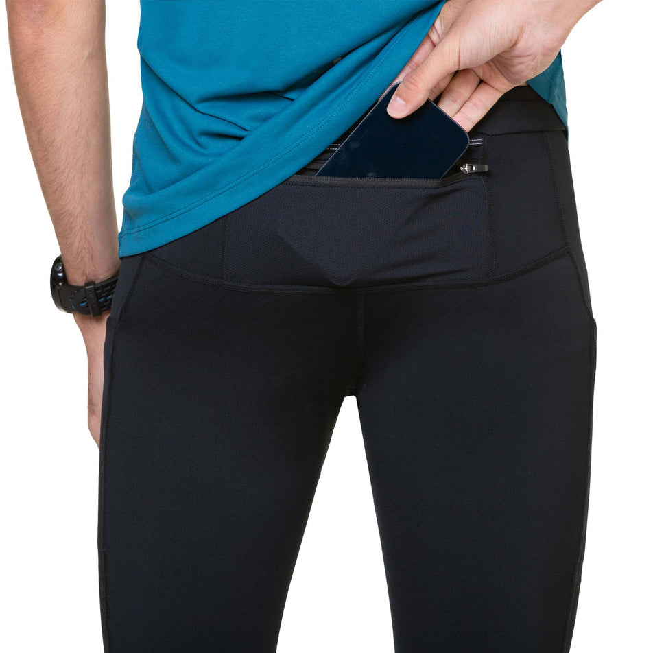 A model demonstrating that a phone can be stored in the back zip pocket of the Ronhill Tech Paragon Tight. (8490275864738)