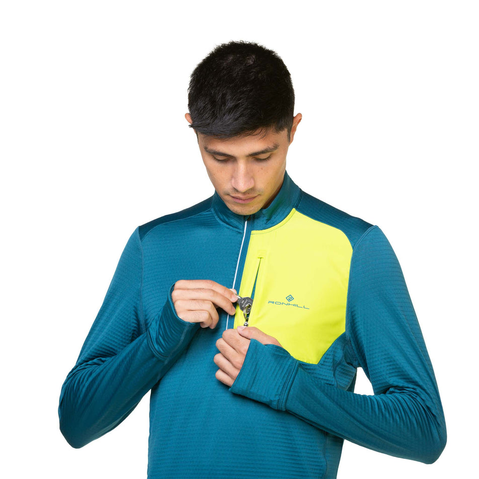 A model demonstrating that a key can be stored in the chest pocket of a Ronhill Men's Tech Winter 1/2 Zip. (8490256990370)