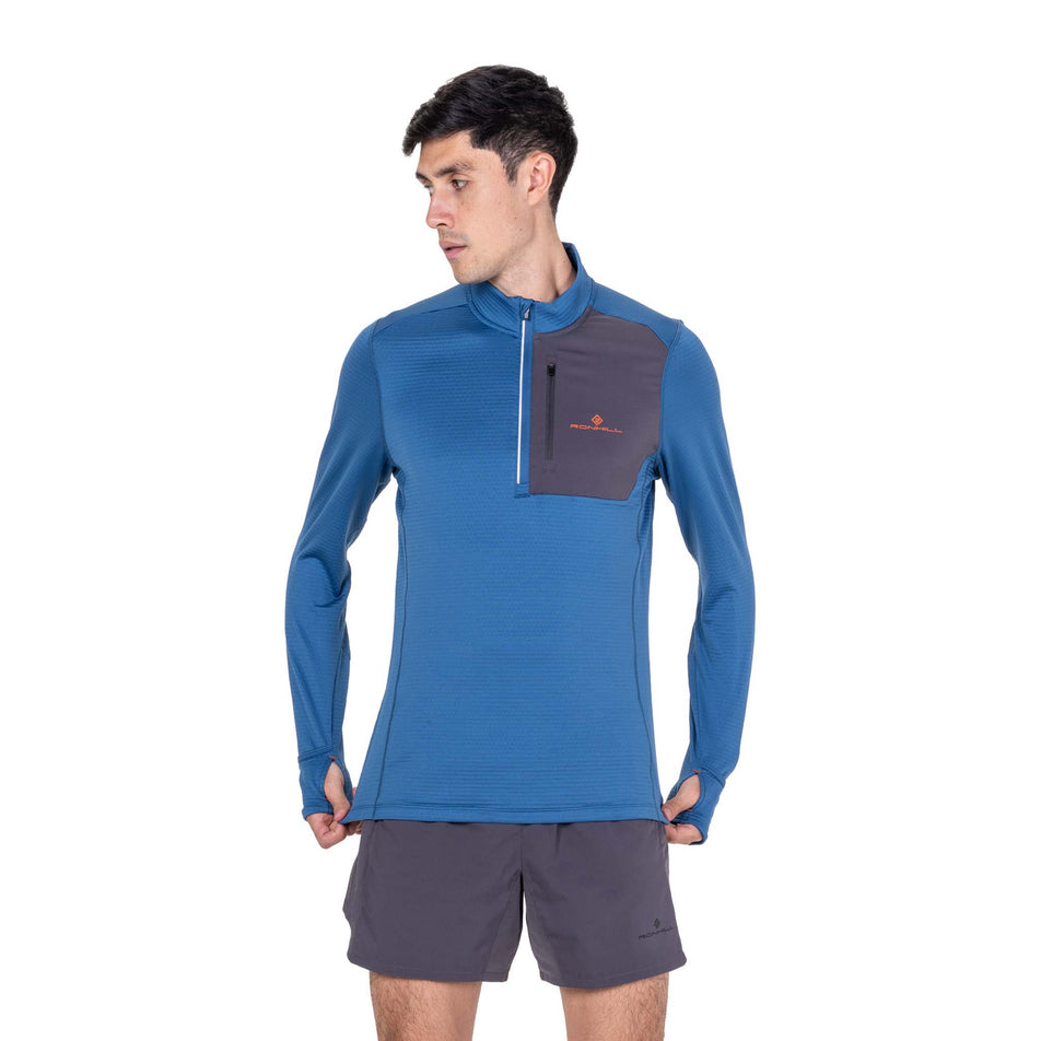 Front view of a model wearing the Ronhill Men's Tech Winter 1/2 Zip in the Glacier/Oxide colourway.