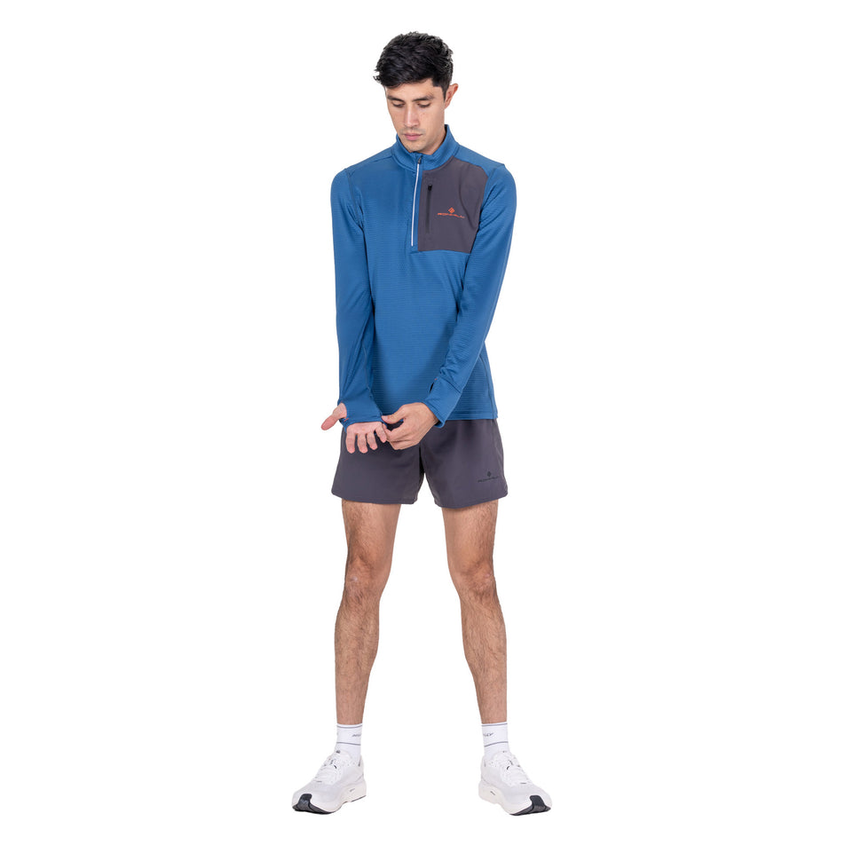 Front view of a model wearing the Ronhill Men's Tech Winter 1/2 Zip in the Glacier/Oxide colourway.