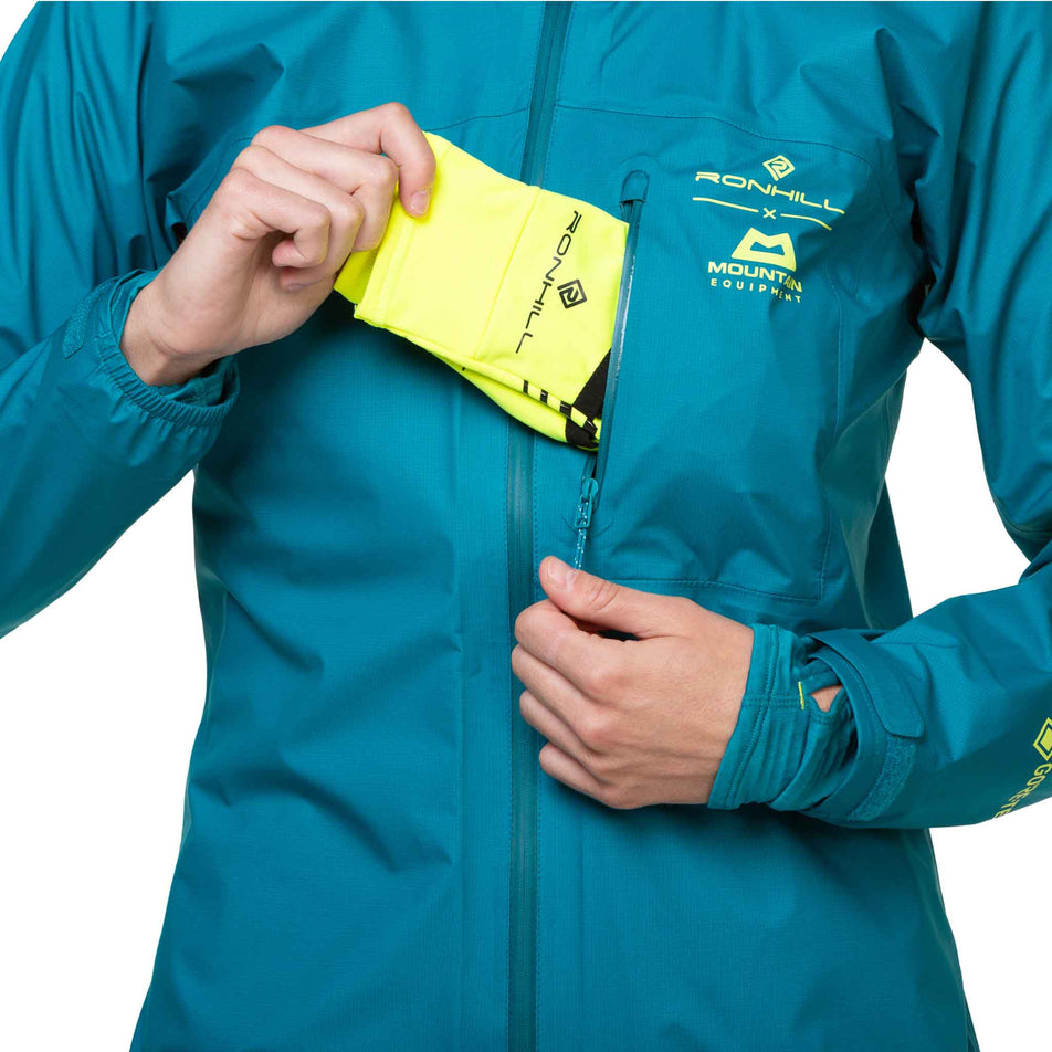 A model demonstrating that gloves can be stored in the chest pocket of a Ronhill Women's Tech GORE-TEX Mercurial Jacket. (8489792307362)