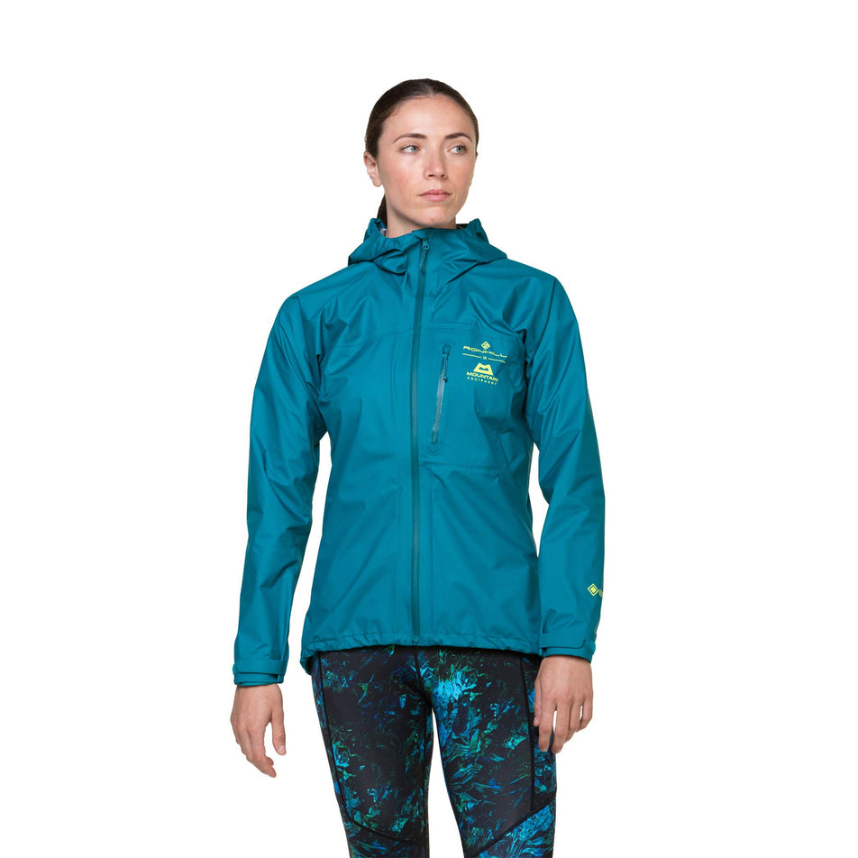 Front view of a model wearing a Ronhill Women's Tech GORE-TEX Mercurial Jacket in the Marine/Acid colourway. Model is also wearing leggings. (8489792307362)