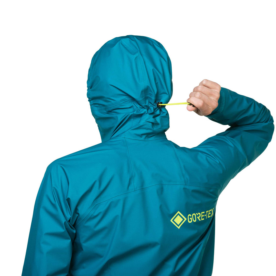 A model demonstrating the adjustment cord on the hood of a Ronhill Women's Tech GORE-TEX Mercurial Jacket. (8489792307362)