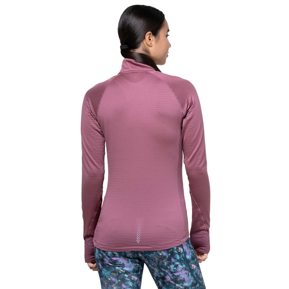 Back view of a model wearing the Ronhill Women's Tech Winter 1/2 Zip in the Dusty Tulip/Dark Navy colourway. (8747552211106)