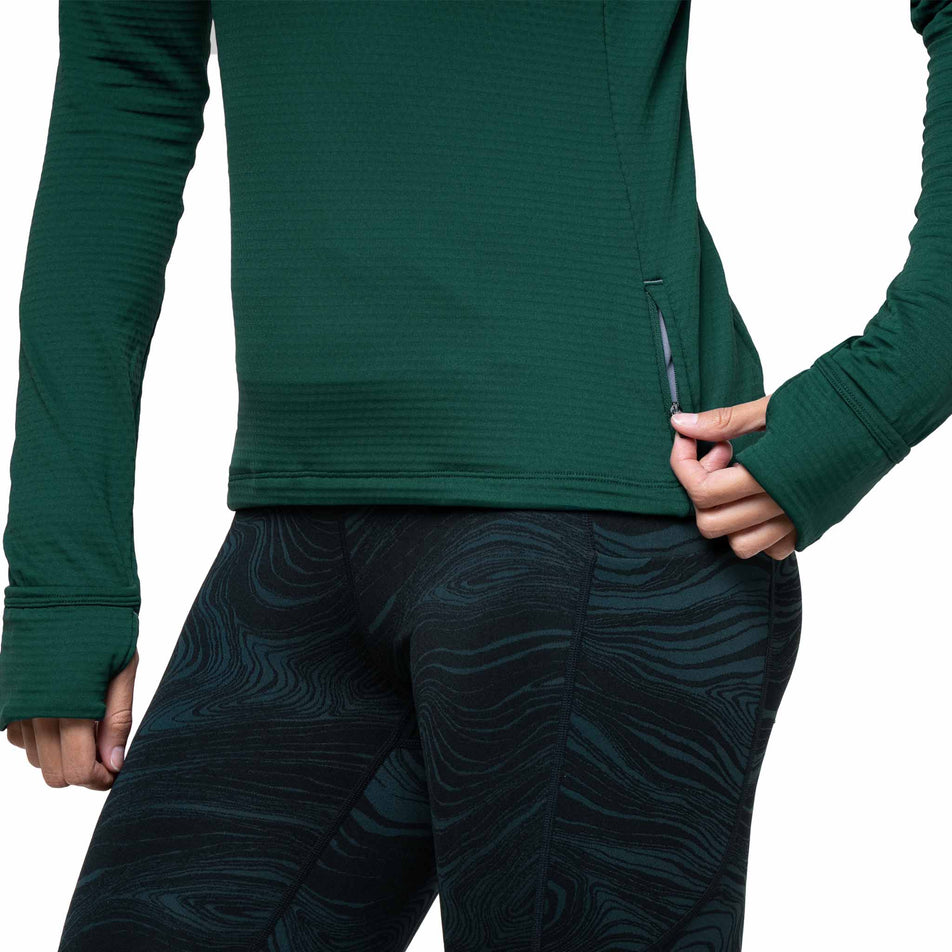 A model demonstrating the zip on the side of the Ronhill Women's Tech Winter 1/2 Zip in the Seaweed/Iris colourway. (8747564925090)