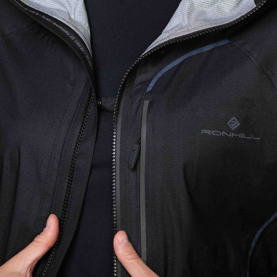 A model demonstrating that the venting tab on the chest of a Ronhill Women's Tech Fortify Jacket Jacket. (8489808429218)