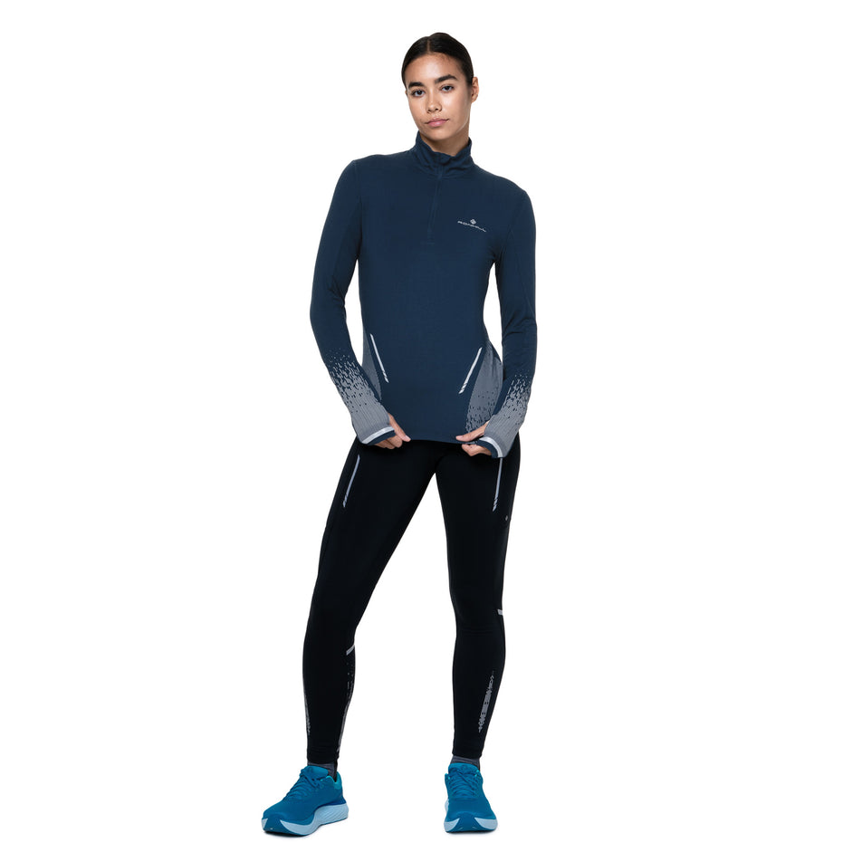 Front view of a model wearing the Ronhill Women's Tech Reflect 1/2 Zip in the Dark Navy/Reflect colourway. (8747154735266)