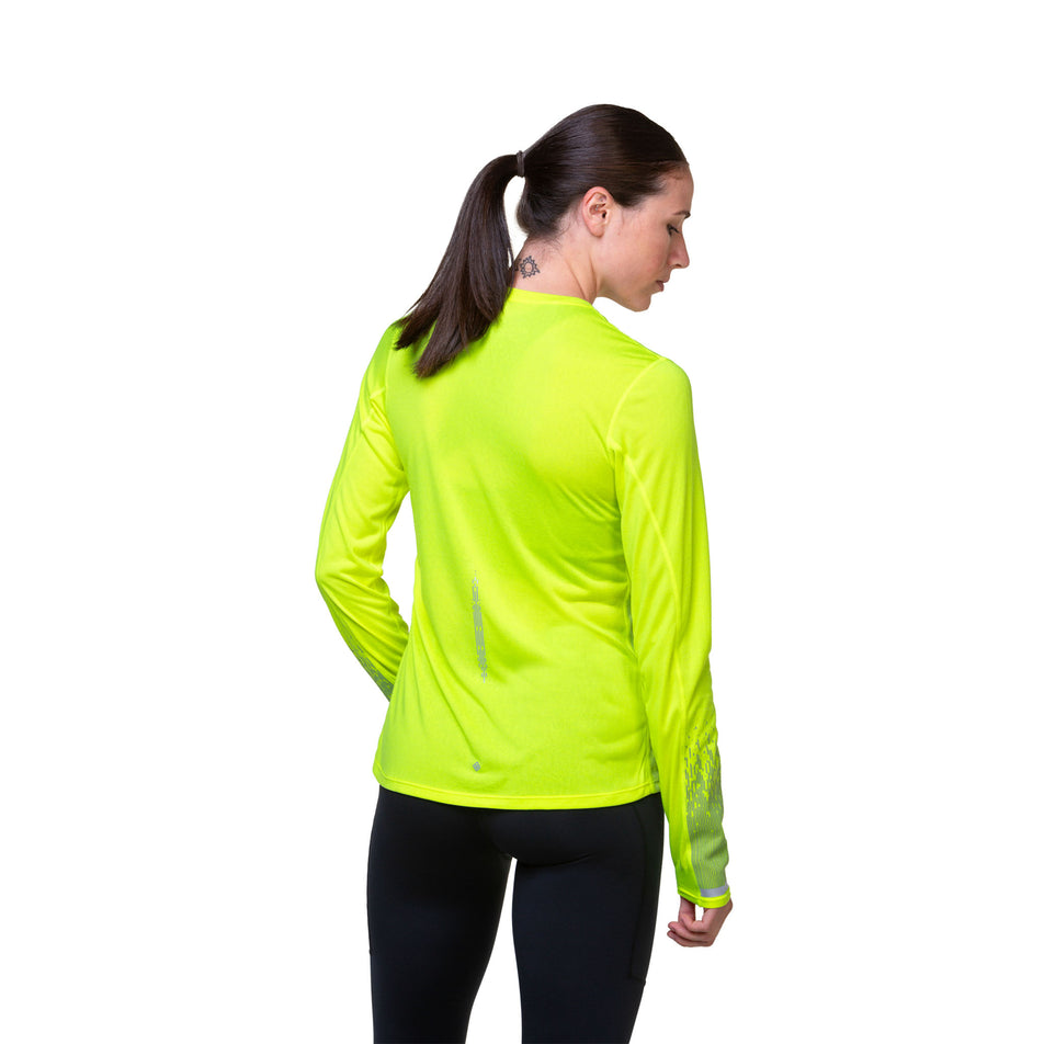 Back view of a model wearing a Ronhill Women's Tech Reflect L/S Tee in the Fluo Yellow/Reflect colourway. Model is also wearing tights. (8489706717346)