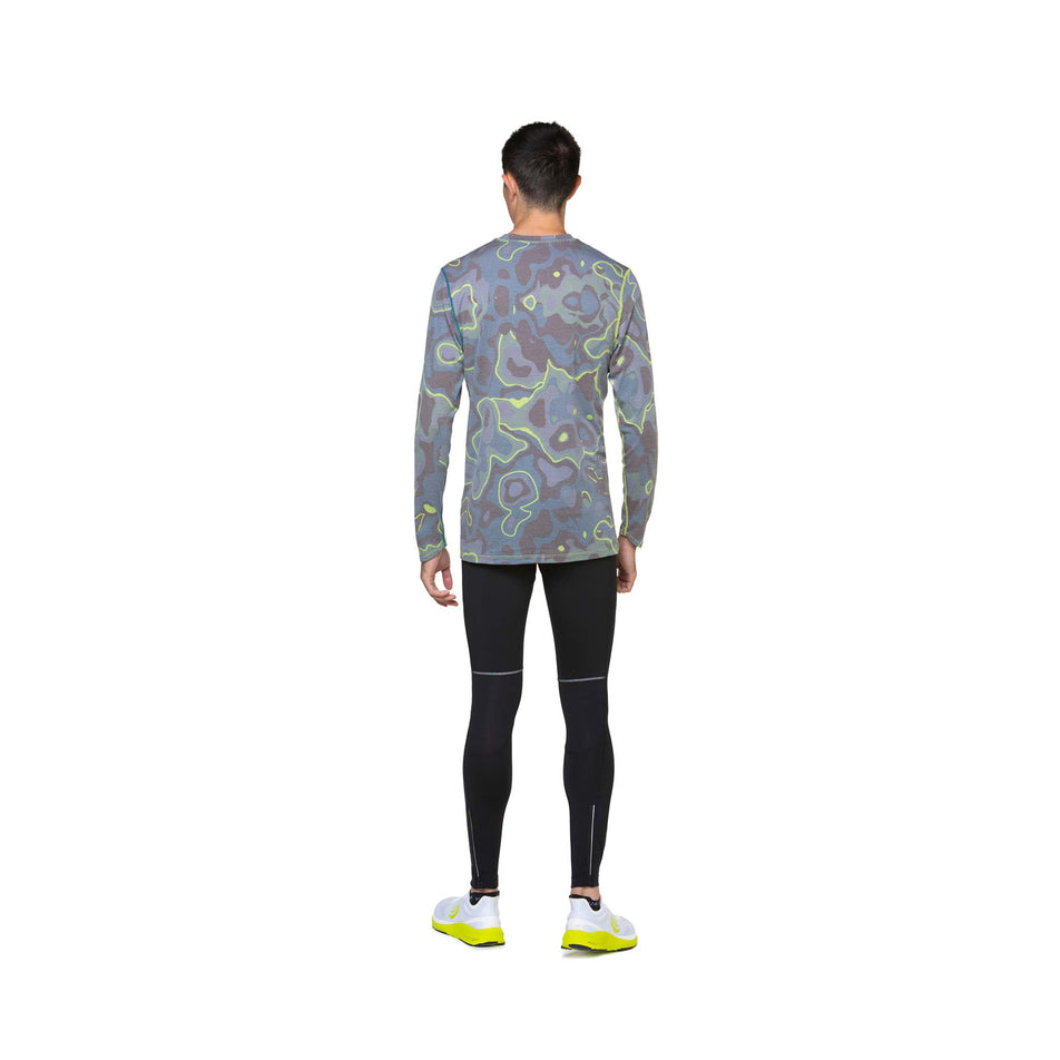 Back view of a model wearing the Ronhill Men's Tech Golden Hour L/S Tee in the Deep Teal Heat Map colourway. Model is also wearing leggings and shoes. (8490280550562)