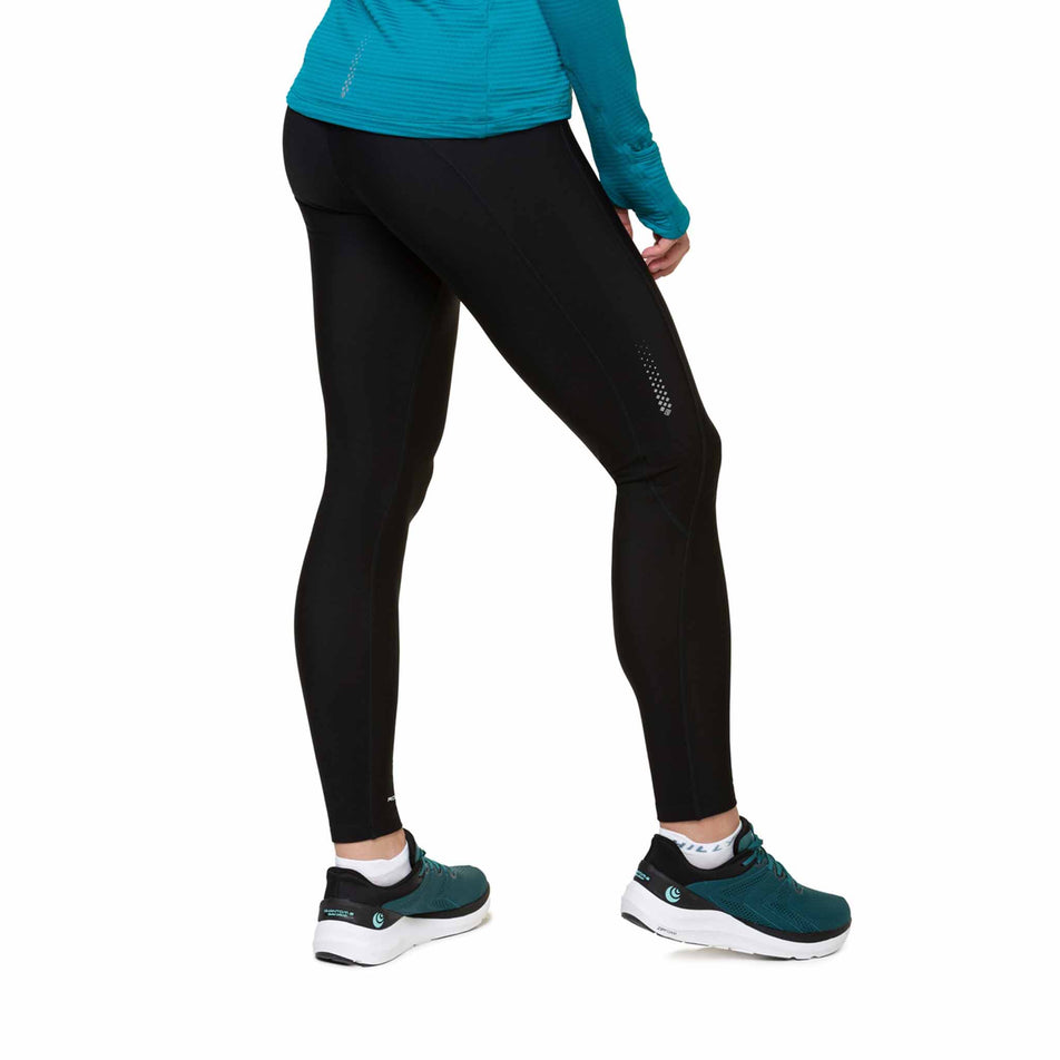 Back view of a model wearing the Ronhill Women's Tech Winter Tight in the All Black colourway. Model is also wearing shoes and a top. (8491198480546)