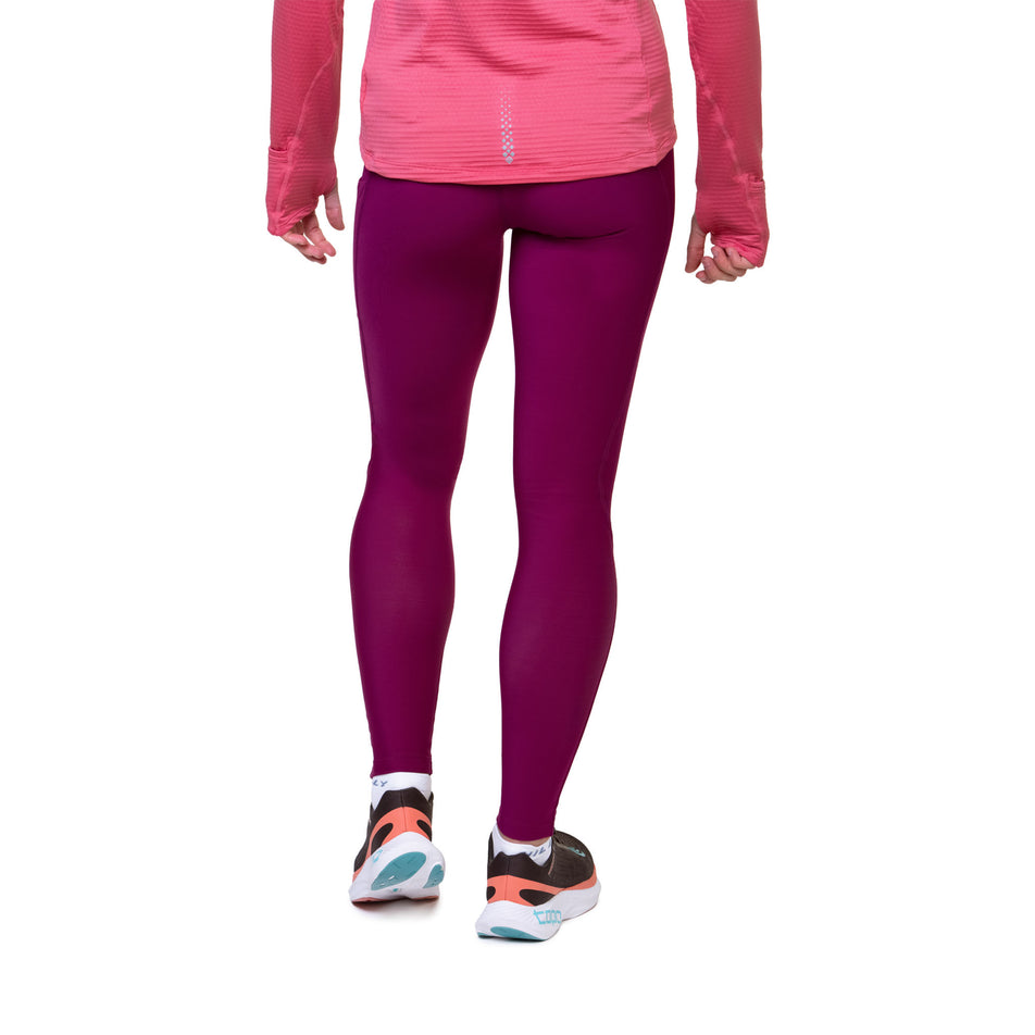 Back view of a model wearing the Ronhill Women's Tech Winter Tight in the Dark Blackcurrant colourway. Model is also wearing a top and shoes. (8489915777186)