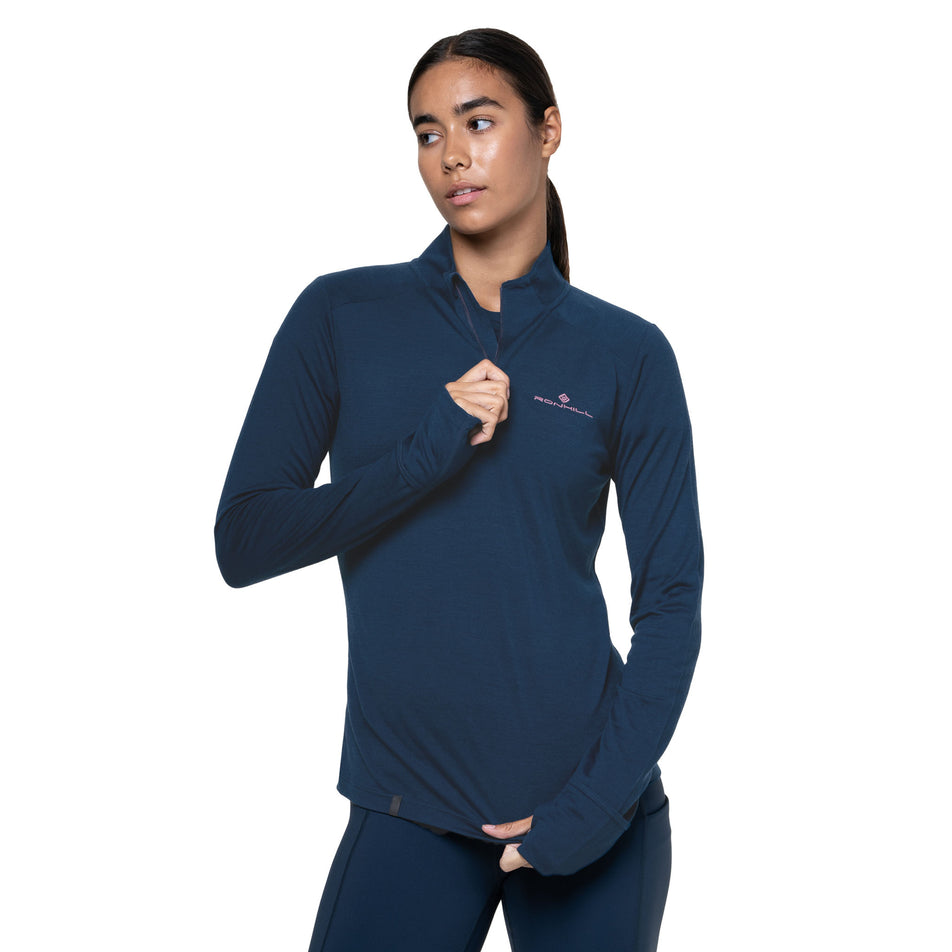 Front view of a model wearing the Ronhill Women's Tech Merino 1/2 Zip in the Dark Navy/Dusty Tulip colourway. (8742204997794)