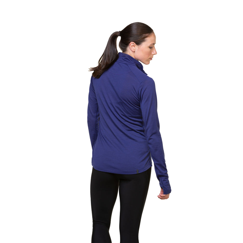 Back view of a model wearing the Ronhill Women's Tech Merino 1/2 Zip in the Deep Ocean/Regal Purple colourway. Model is also wearing leggings. (8489925181602)