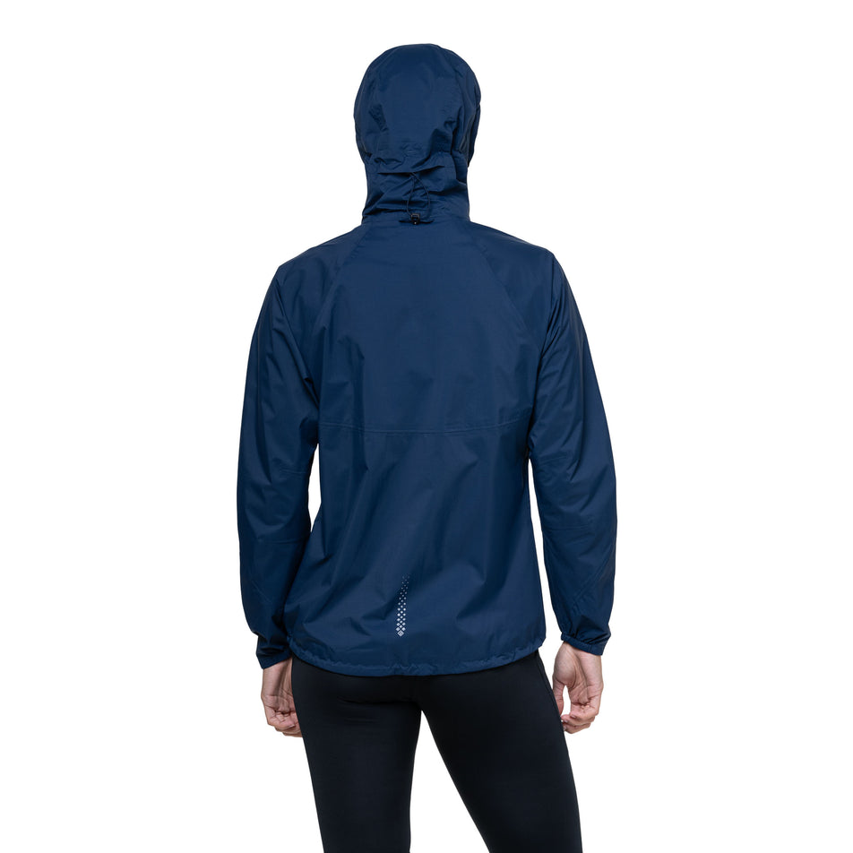 Back view of a model wearing the Ronhill Women's Tech Storm Jacket in the Dark Navy colourway. (8742197559458)