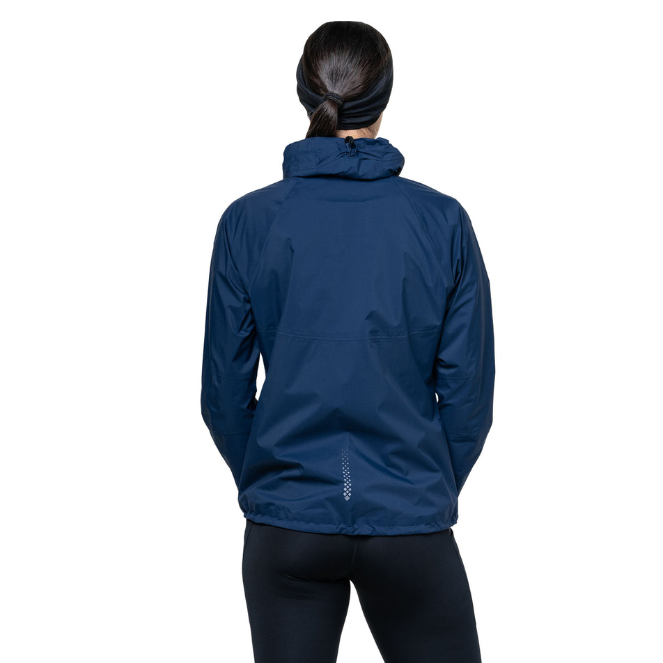 Back view of a model wearing the Ronhill Women's Tech Storm Jacket in the Dark Navy colourway. (8742197559458)