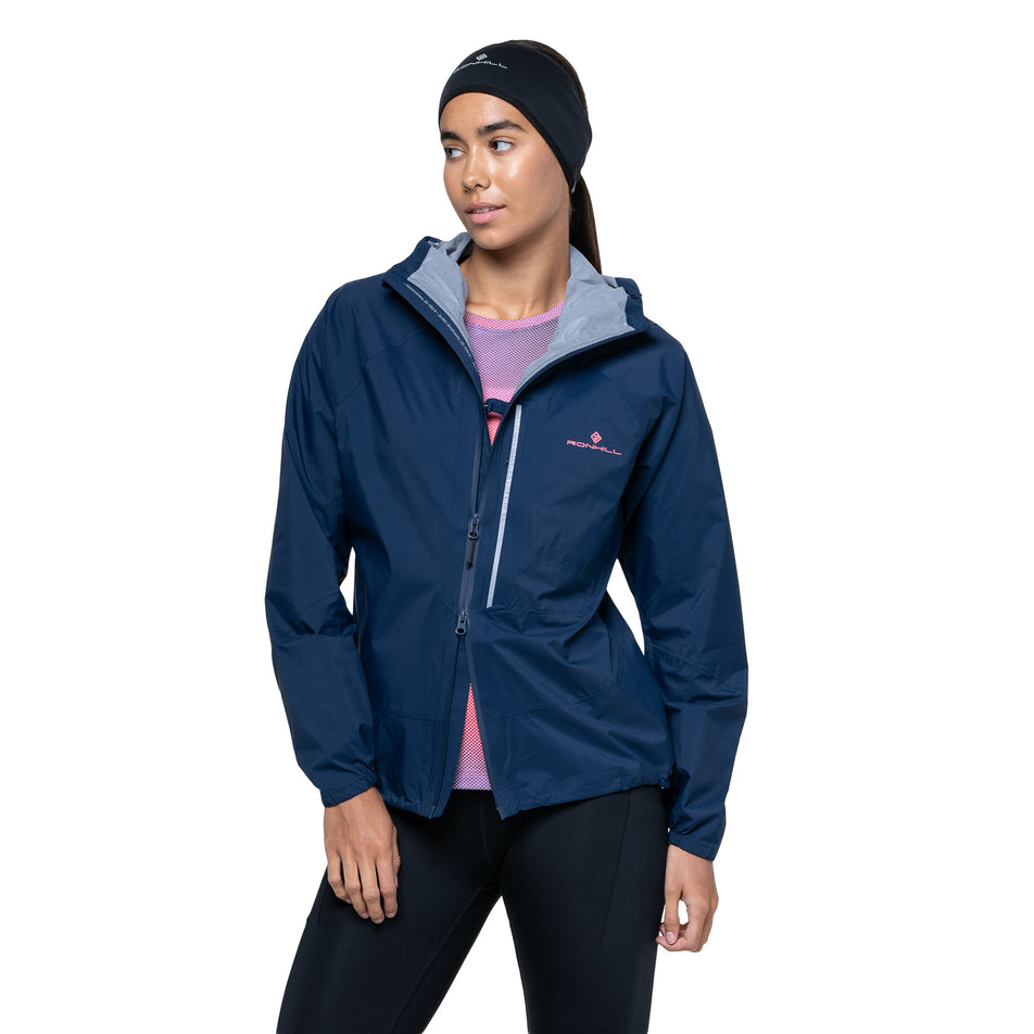 A model demonstrating the open-end zip on the Ronhill Women's Tech Storm Jacket in the Dark Navy colourway. (8742197559458)