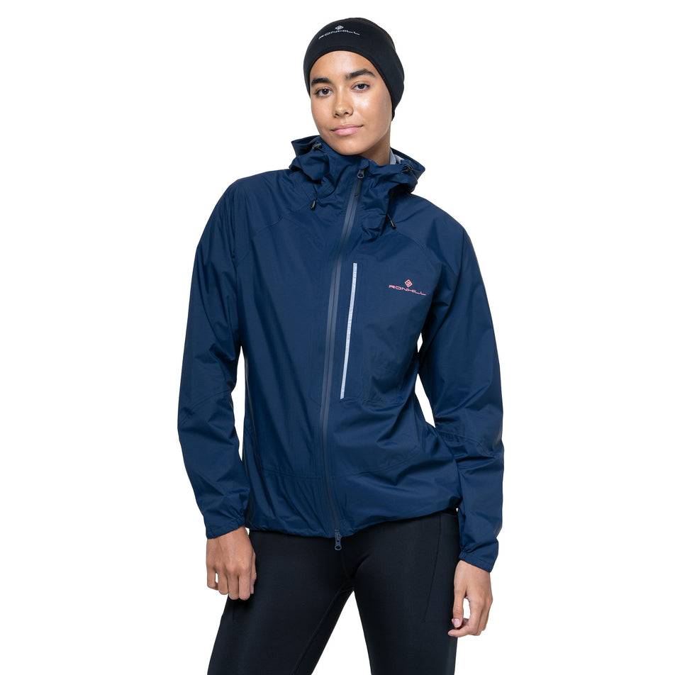 Front view of a model wearing the Ronhill Women's Tech Storm Jacket in the Dark Navy colourway. (8742197559458)