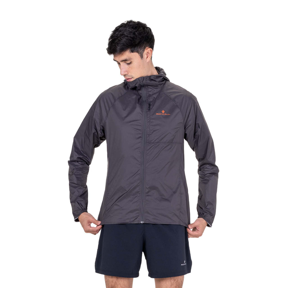 Front view of a model wearing the Ronhill Men's Tech All-Terrain Jacket in the Oxide/Ronhill Red colourway.