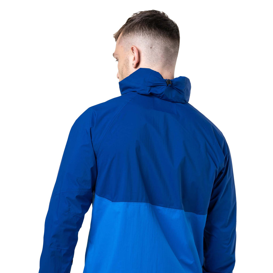Back view of a model wearing the Ronhill Men's Tech Storm Jacket in the Ocean/Electric Blue colourway. (8742825853090)