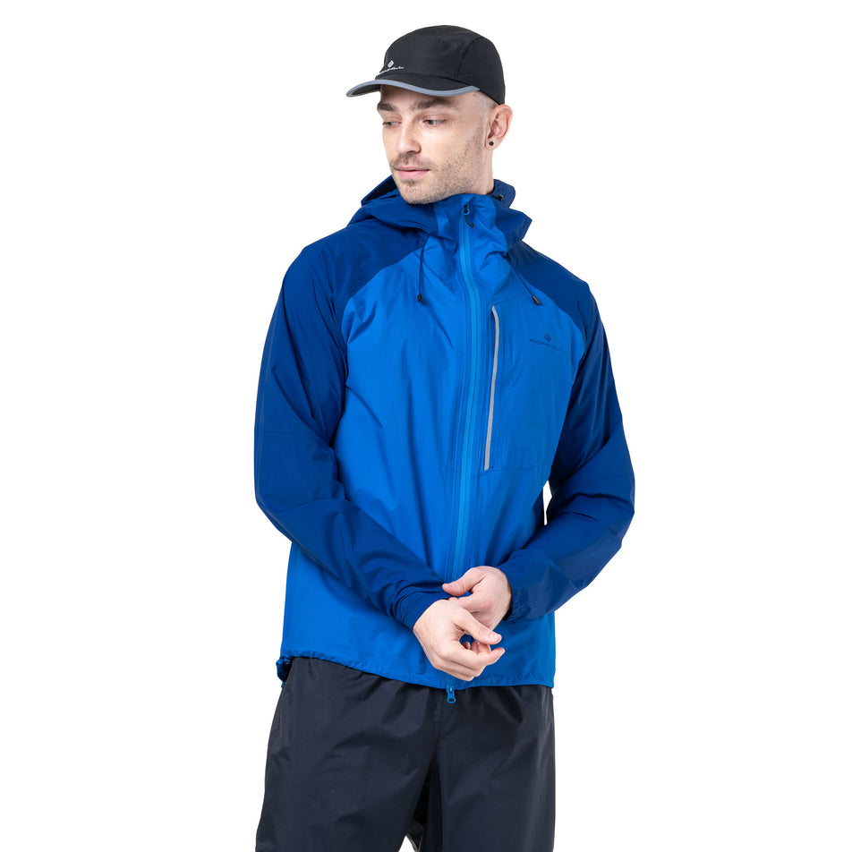 Front view of a model wearing the Ronhill Men's Tech Storm Jacket in the Ocean/Electric Blue colourway. (8742825853090)