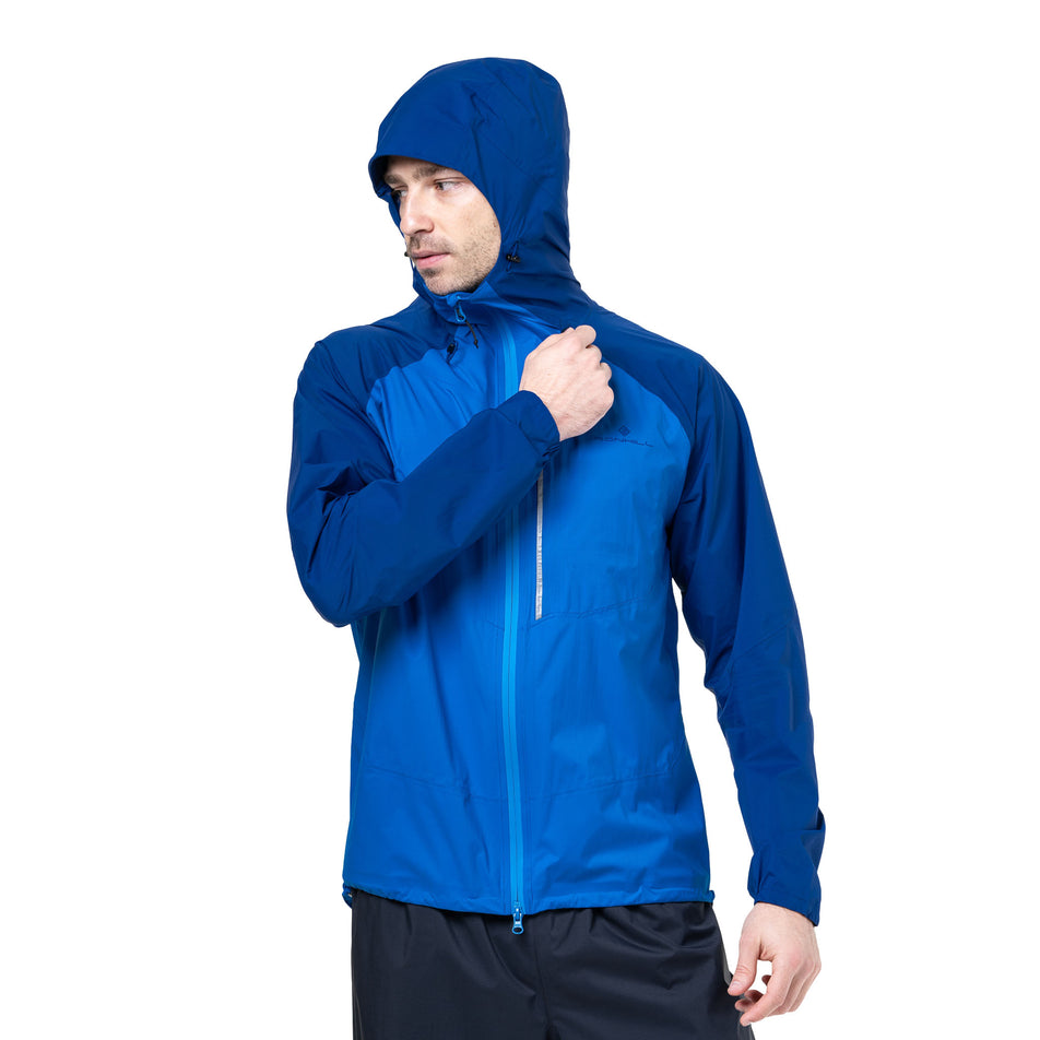 Front view of a model wearing the Ronhill Men's Tech Storm Jacket in the Ocean/Electric Blue colourway. (8742825853090)