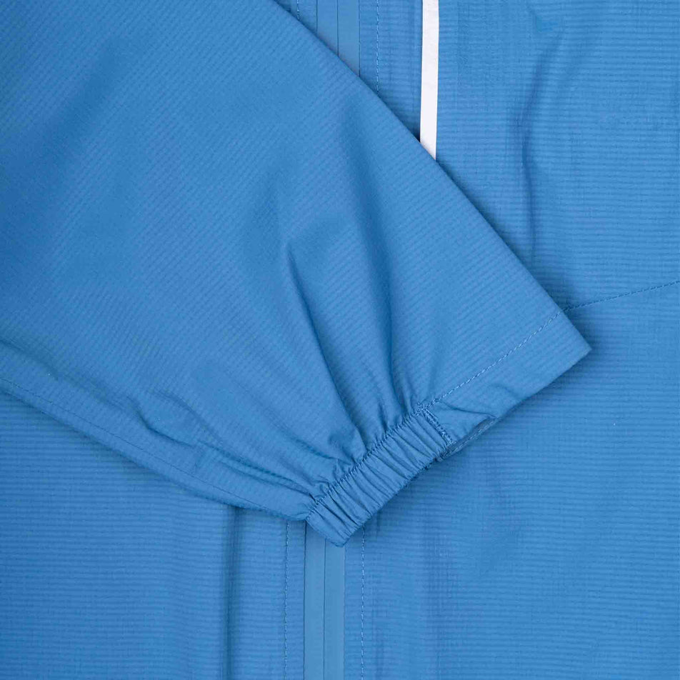 Close-up view of the sleeve of the Ronhill Men's Tech Storm Jacket in the Glacier/Ronhill Red colourway.