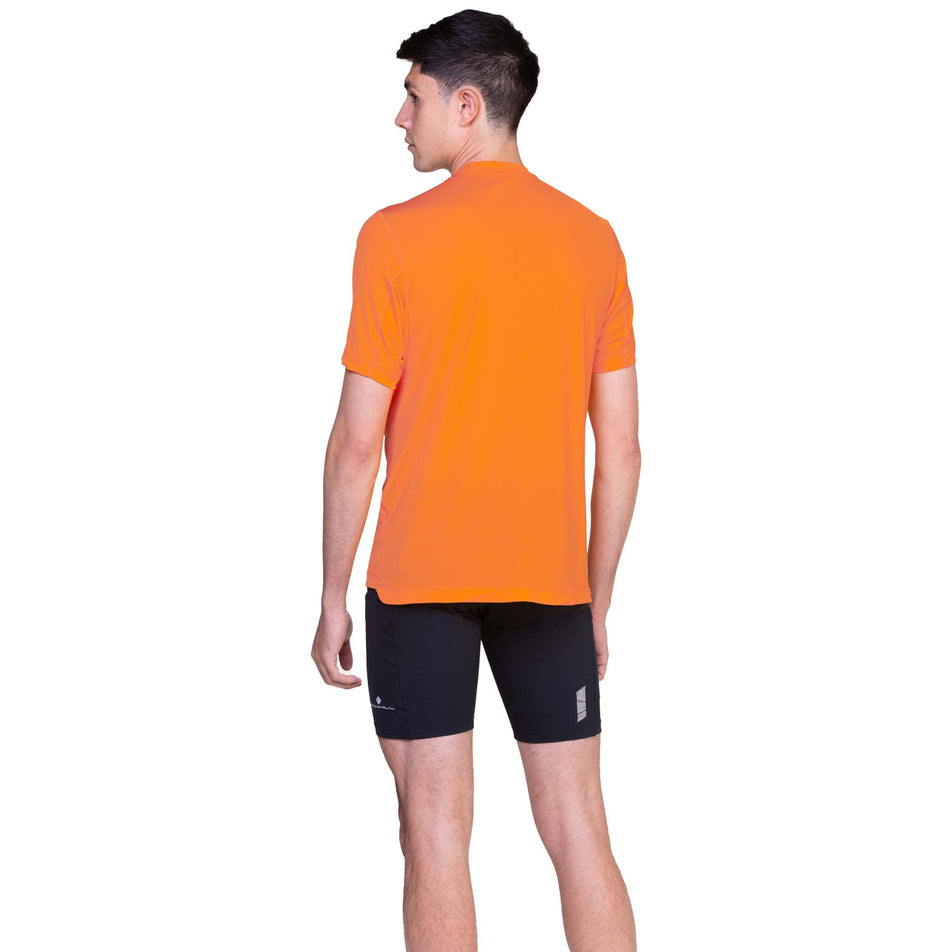 Back view of a model wearing the Ronhill Men's Tech S/S Tee in the Tangelo/Black colourway. (8563613925538)
