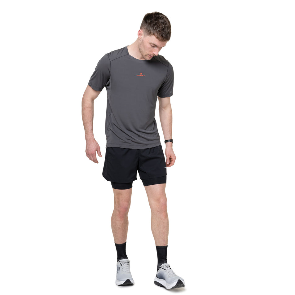 Front view of a model wearing the Ronhill Men's Tech S/S Tee in the Oxide/Ronhill Red colourway.