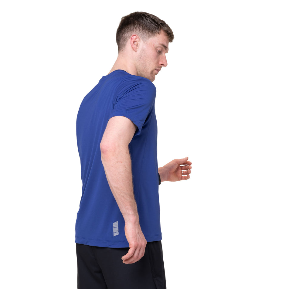 Side view of a model wearing the Ronhill Men's Tech S/S Tee in the Dark Cobalt/Fluo Green colourway.