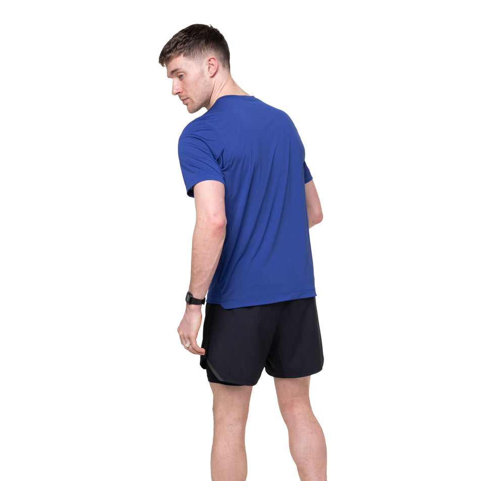 Back view of a model wearing the Ronhill Men's Tech S/S Tee in the Dark Cobalt/Fluo Green colourway.