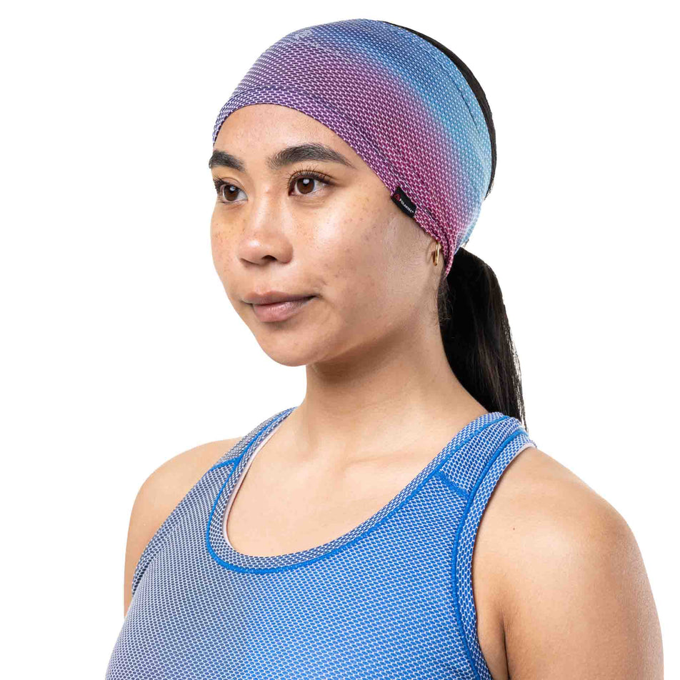 Front view of a model wearing the Ronhill Unisex Golden Hour Headband in the Exuberance Merge colourway.