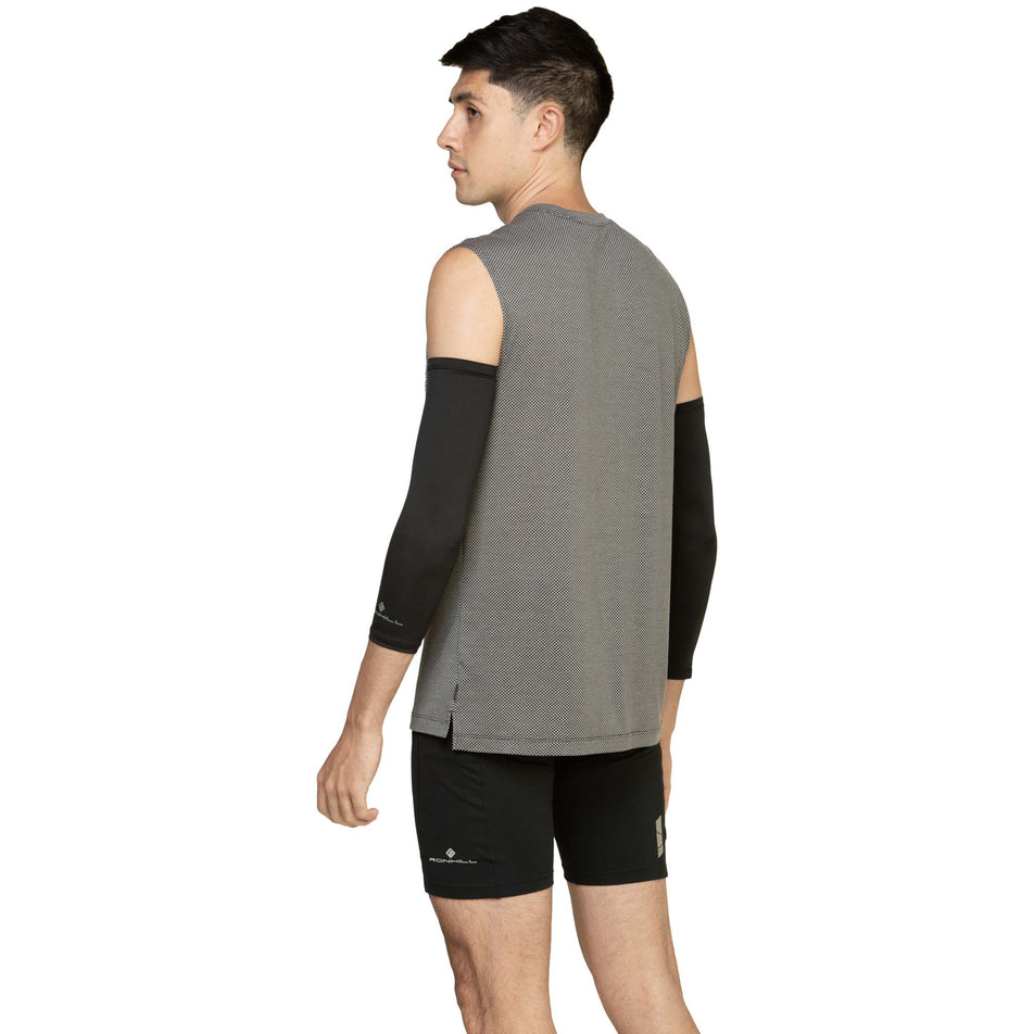 Back view of a model wearing the Ronhill Unisex Race Arm Sleeves in the All Black colourway. (8577360822434)