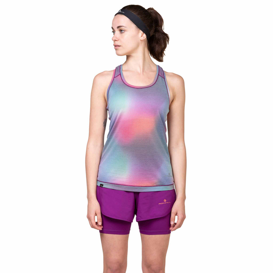 Front view of a model wearing the Ronhill Women's Tech Golden Hour Vest in the Aurora Glow colourway. (8564966031522)