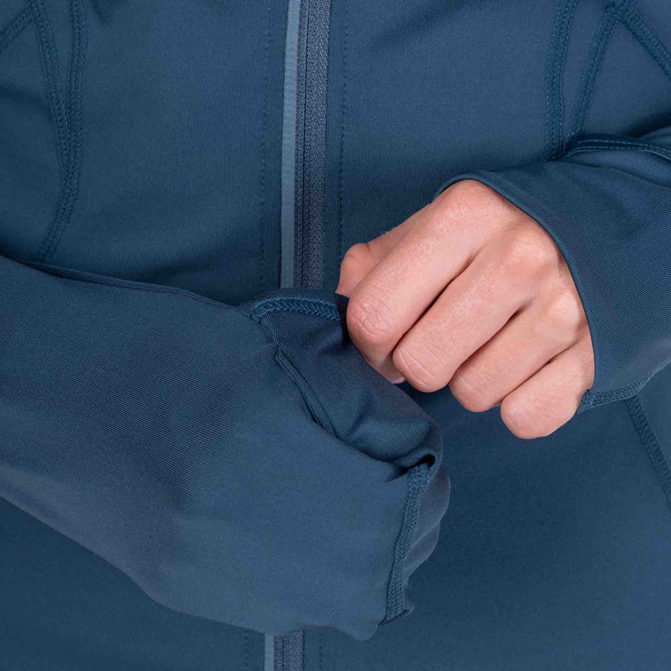Close-up view of a model demonstrating the thumb loops and over mitt on the Ronhill Women's Tech Contour Jacket in the Evening Haze colourway.