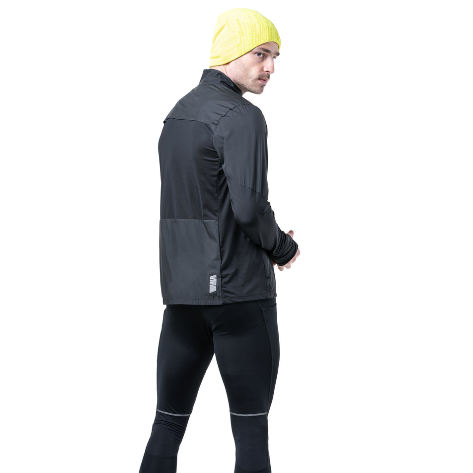 Angled view of a model wearing the Ronhill Men's Tech Wind-Block 1/2 Zip in the All Black colourway. (8742870352034)