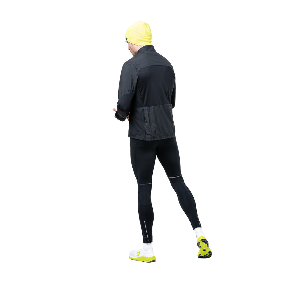 Angled view of a model wearing the Ronhill Men's Tech Wind-Block 1/2 Zip in the All Black colourway. (8742870352034)